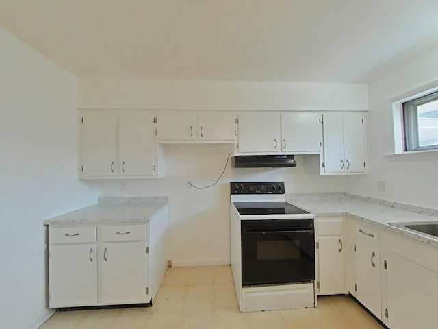 kitchen with electric stove and white cabinets