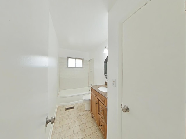 full bathroom with tile patterned floors, tiled shower / bath, vanity, and toilet