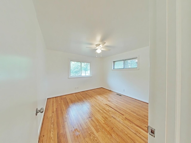 empty room with ceiling fan and hardwood / wood-style flooring