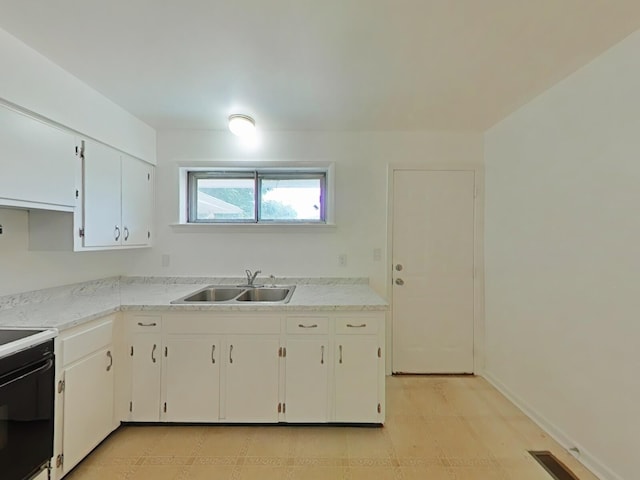 kitchen featuring black / electric stove, white cabinetry, and sink