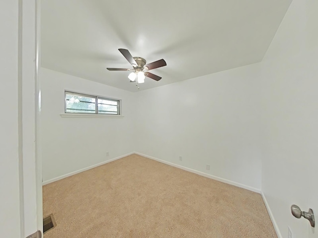 empty room featuring ceiling fan and light carpet