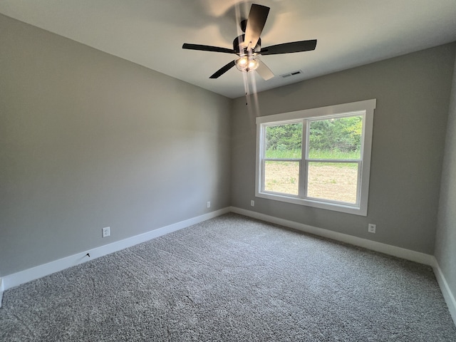 carpeted spare room featuring ceiling fan