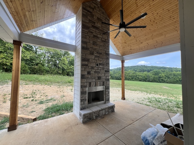 view of patio with ceiling fan and an outdoor stone fireplace