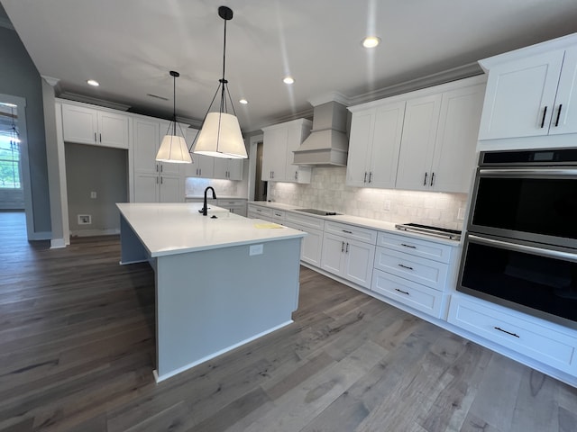 kitchen featuring custom exhaust hood, hanging light fixtures, white cabinetry, double oven, and hardwood / wood-style floors