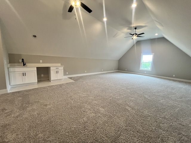 bonus room with vaulted ceiling, light carpet, ceiling fan, and sink