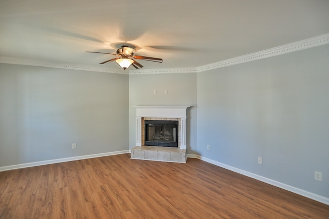 unfurnished living room featuring a tile fireplace, hardwood / wood-style flooring, ceiling fan, and crown molding