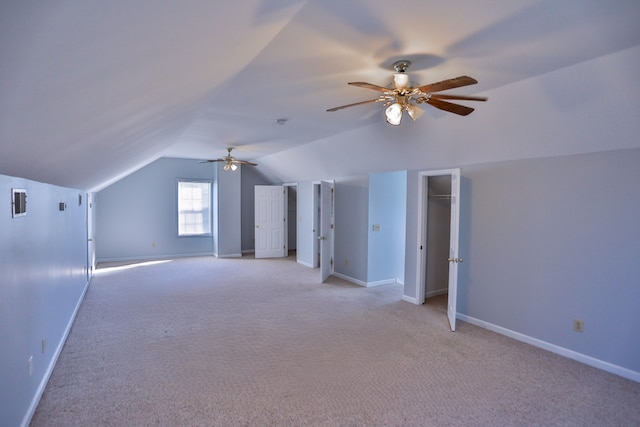 additional living space with ceiling fan, light colored carpet, and lofted ceiling