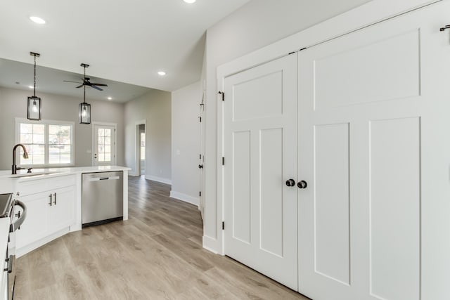 kitchen featuring ceiling fan, light wood-type flooring, sink, and appliances with stainless steel finishes