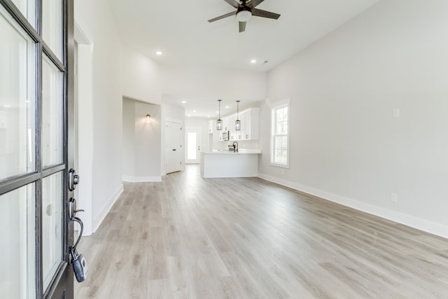 unfurnished living room with light hardwood / wood-style flooring and ceiling fan