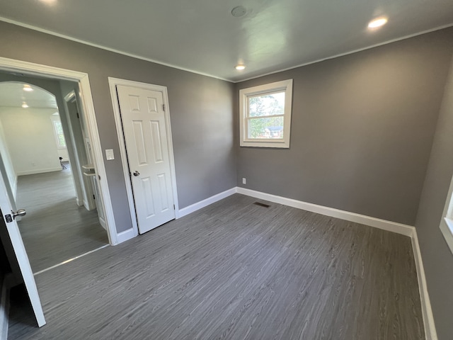 unfurnished bedroom with dark hardwood / wood-style flooring and a closet