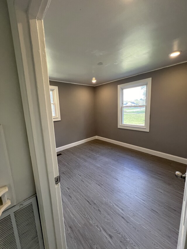 unfurnished room with crown molding and dark hardwood / wood-style floors