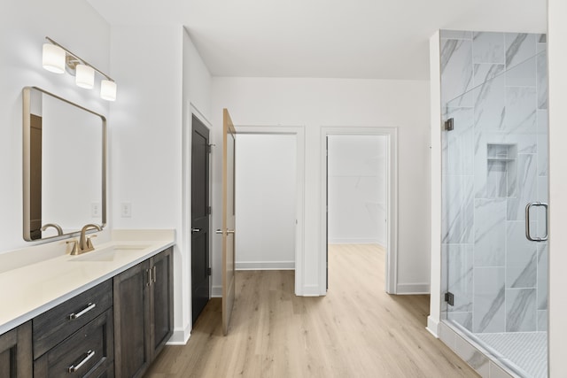 bathroom featuring hardwood / wood-style flooring, vanity, and a shower with shower door