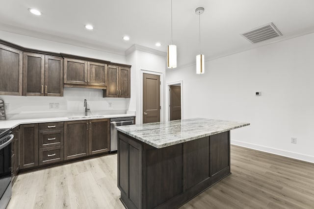 kitchen with light hardwood / wood-style floors, a kitchen island, stainless steel dishwasher, ornamental molding, and sink