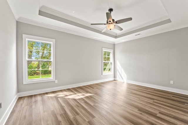 spare room featuring ceiling fan, wood-type flooring, and a healthy amount of sunlight