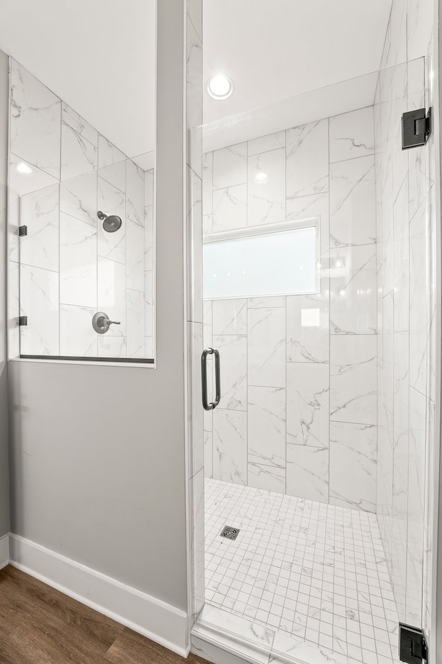 bathroom featuring hardwood / wood-style flooring and a shower with shower door