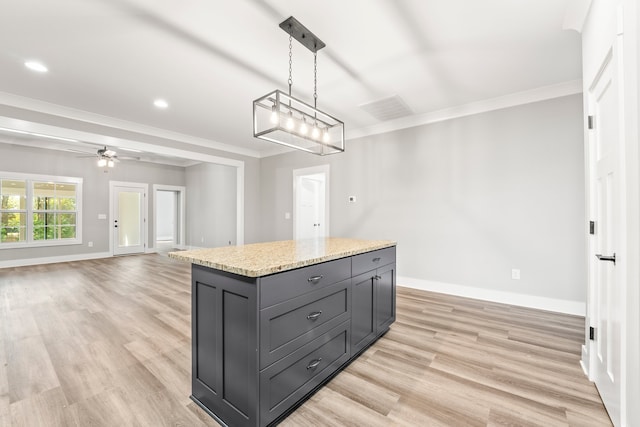 kitchen with ceiling fan with notable chandelier, a kitchen island, light hardwood / wood-style flooring, and decorative light fixtures