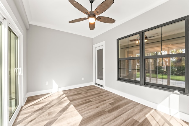 empty room with ceiling fan, crown molding, light hardwood / wood-style floors, and a wealth of natural light