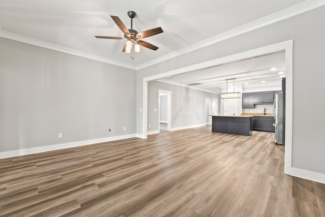 unfurnished living room with ceiling fan, dark hardwood / wood-style floors, and ornamental molding