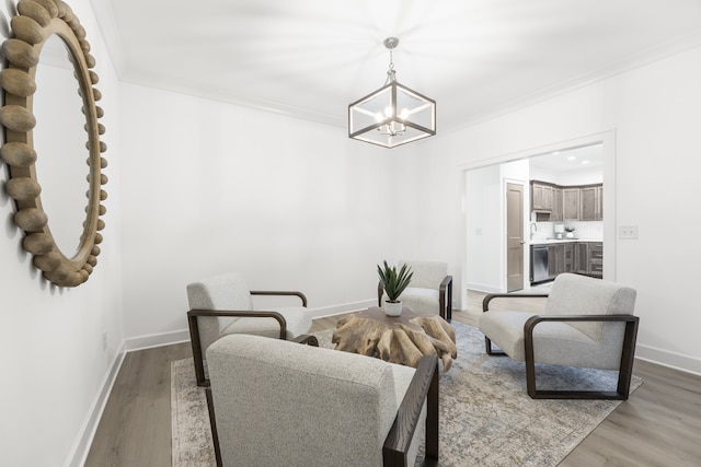 interior space featuring a notable chandelier, light wood-type flooring, and ornamental molding