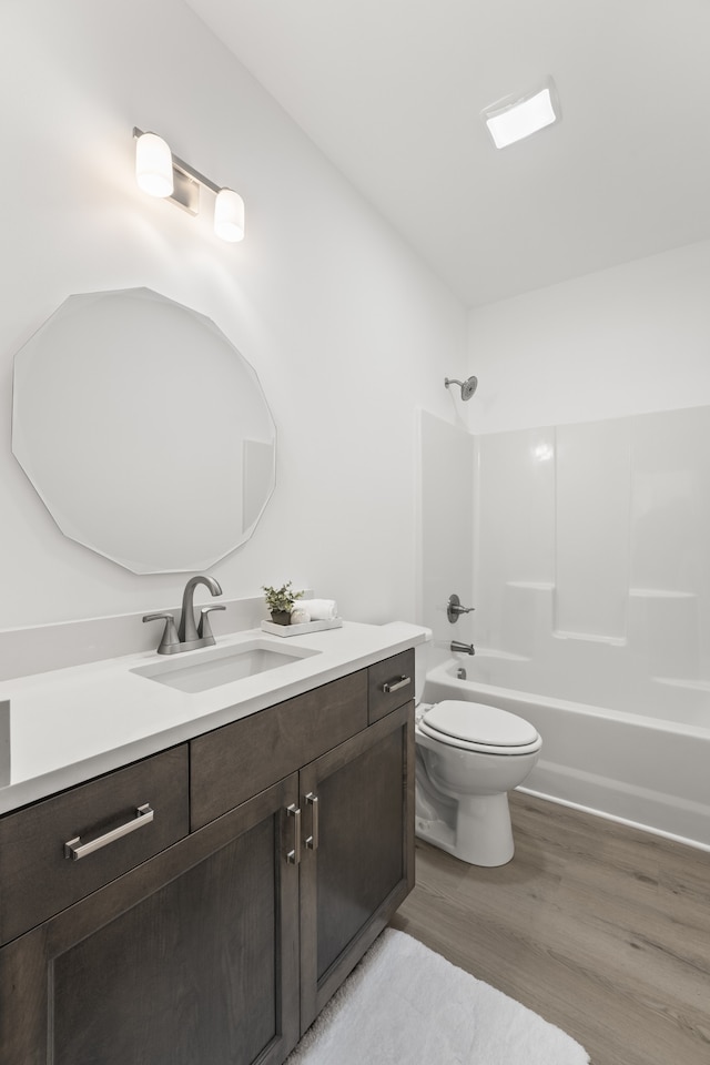 full bathroom with tub / shower combination, hardwood / wood-style flooring, vanity, and toilet