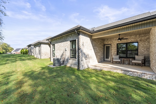 rear view of property featuring a patio, a yard, ceiling fan, and central AC