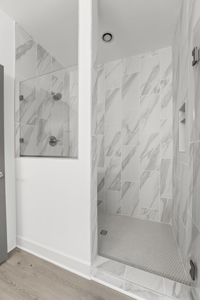 bathroom featuring tiled shower and hardwood / wood-style floors