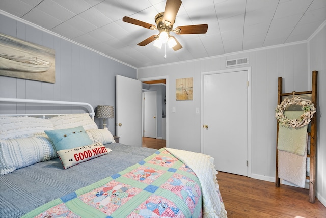 bedroom with crown molding, hardwood / wood-style floors, and ceiling fan