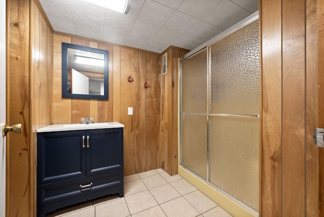full bath with wood walls, a stall shower, tile patterned flooring, and vanity