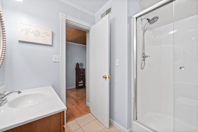 bathroom featuring tile patterned flooring, walk in shower, vanity, and crown molding