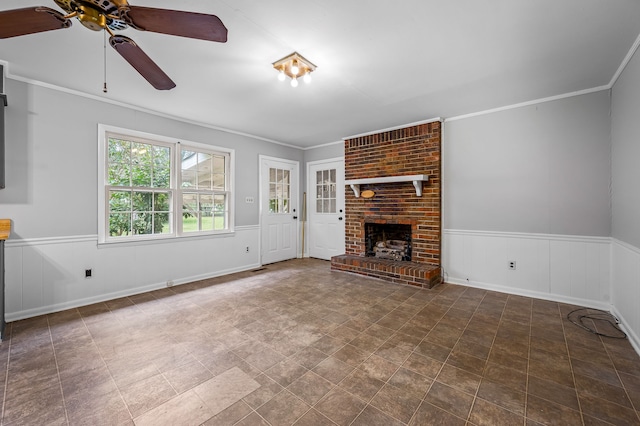 unfurnished living room with ornamental molding, ceiling fan, and a brick fireplace