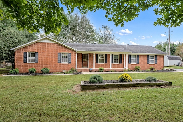 ranch-style house featuring a storage unit and a front yard