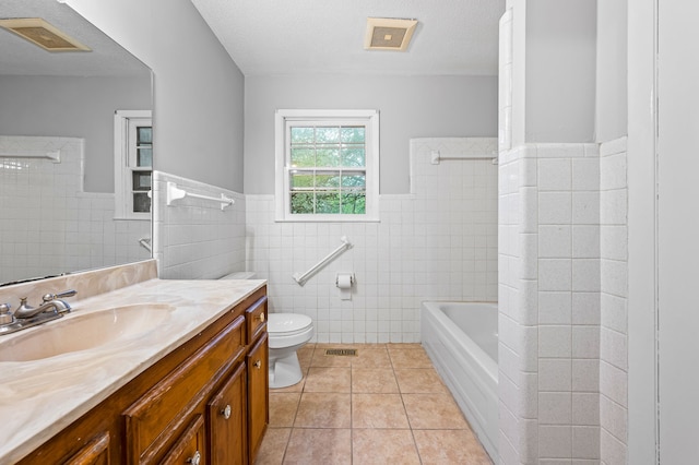 full bathroom featuring vanity, toilet, a textured ceiling, and tile patterned floors