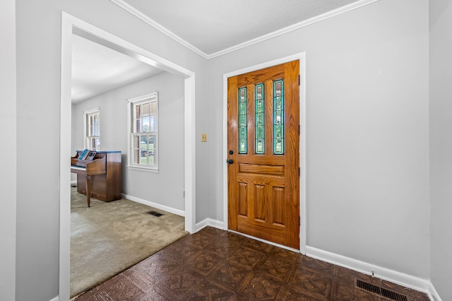 carpeted entrance foyer featuring a textured ceiling and crown molding