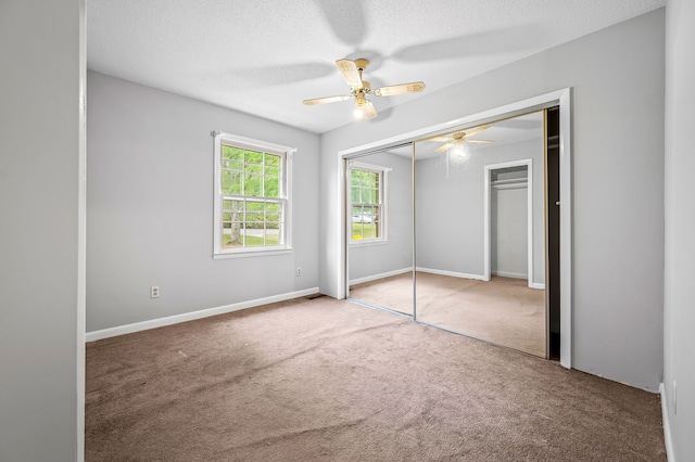 unfurnished bedroom featuring a closet, carpet, ceiling fan, and a textured ceiling