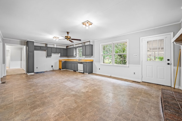 unfurnished living room with ornamental molding, sink, and ceiling fan