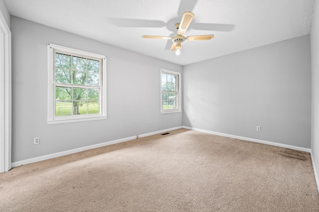 unfurnished room featuring ceiling fan and carpet