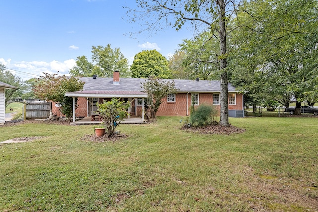 rear view of house with a lawn, central AC unit, and a patio area