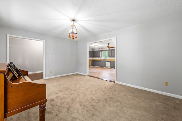 interior space with a notable chandelier, a textured ceiling, carpet floors, and sink