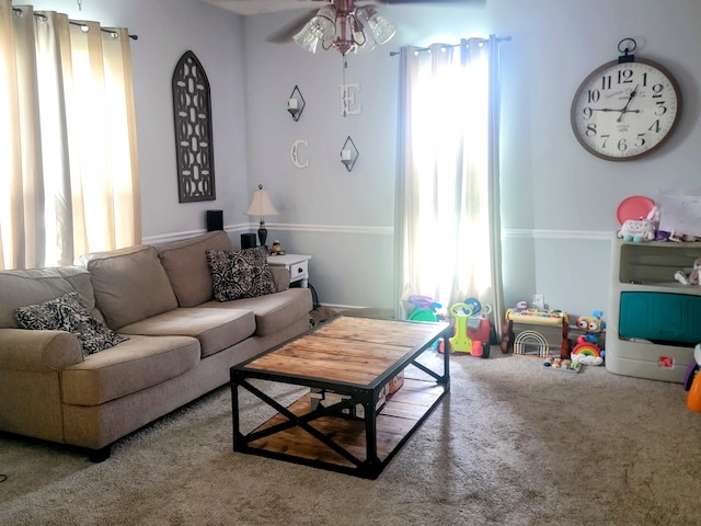 living room featuring ceiling fan, carpet flooring, and a wealth of natural light