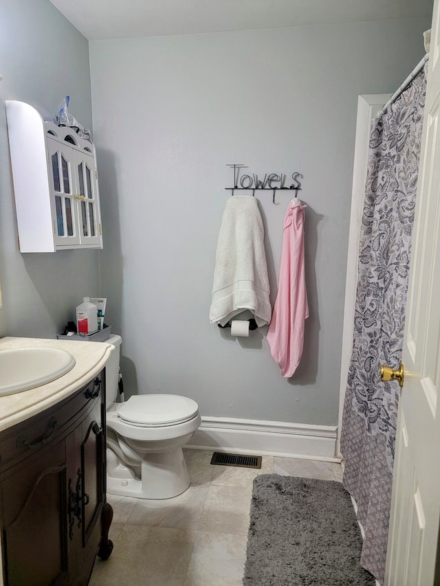 bathroom with vanity, toilet, and tile patterned flooring