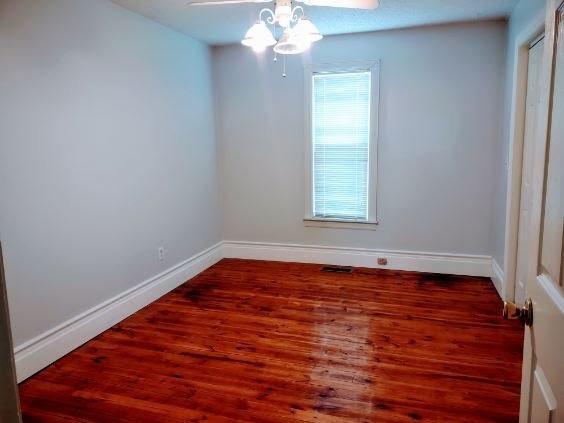 empty room featuring dark hardwood / wood-style floors and ceiling fan