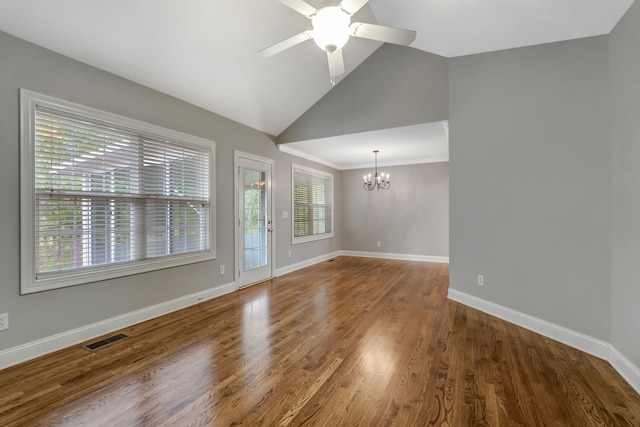 empty room featuring hardwood / wood-style flooring, ceiling fan with notable chandelier, high vaulted ceiling, and ornamental molding