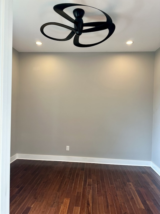 empty room with ceiling fan and dark hardwood / wood-style flooring