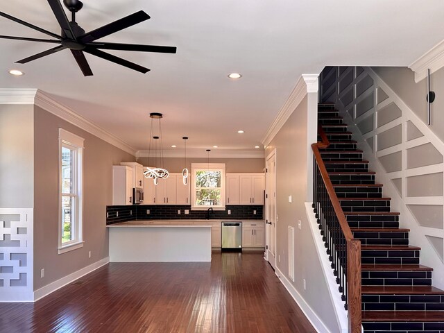 kitchen with appliances with stainless steel finishes, pendant lighting, white cabinets, and tasteful backsplash