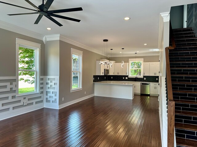 kitchen with white cabinets, decorative light fixtures, stainless steel appliances, tasteful backsplash, and ornamental molding