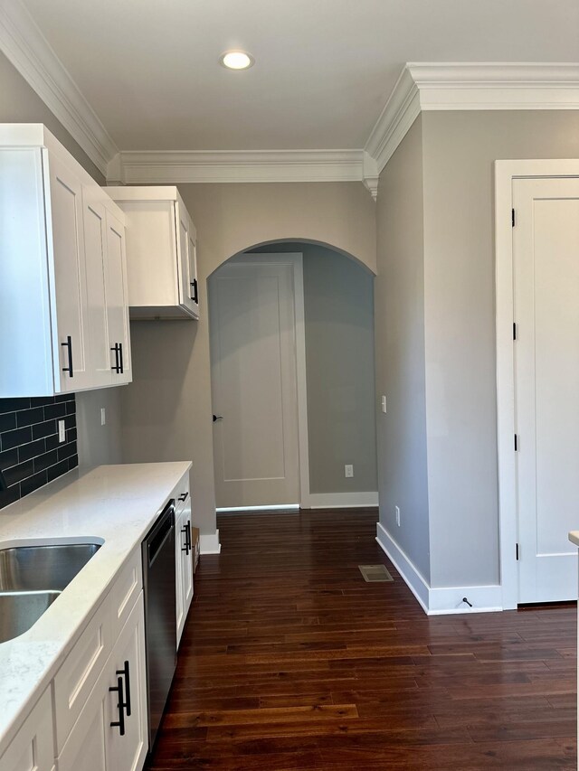 kitchen featuring decorative backsplash, white cabinetry, dishwasher, and crown molding