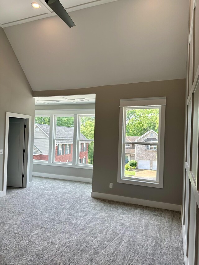 empty room featuring ceiling fan, light colored carpet, and vaulted ceiling