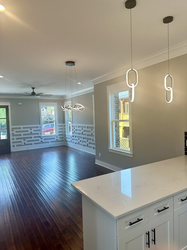 kitchen with decorative light fixtures, white cabinets, and crown molding