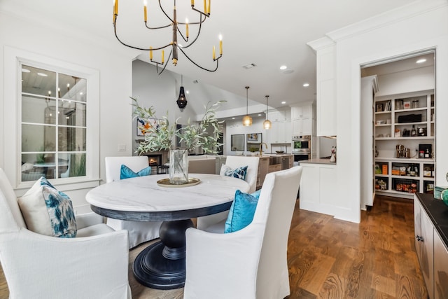 dining space featuring crown molding, sink, dark hardwood / wood-style floors, and a notable chandelier