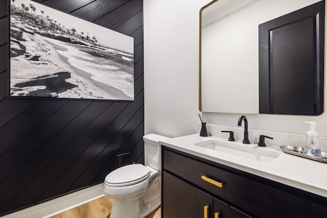 bathroom featuring vanity, wood-type flooring, and toilet